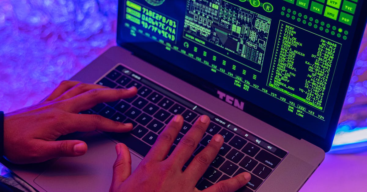 Close-up of hands typing on a laptop displaying green code, indoors, purple lighting.