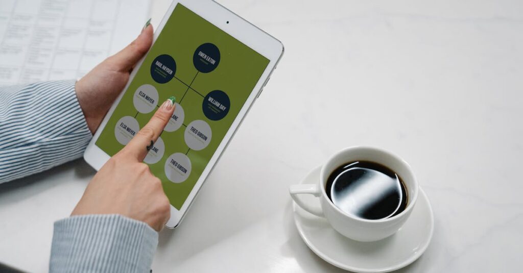 Hands holding a tablet with a diagram, next to a cup of black coffee on a desk, symbolizing modern work life.