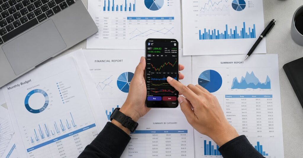 Business person reviews financial data and graphs on a mobile device surrounded by reports.